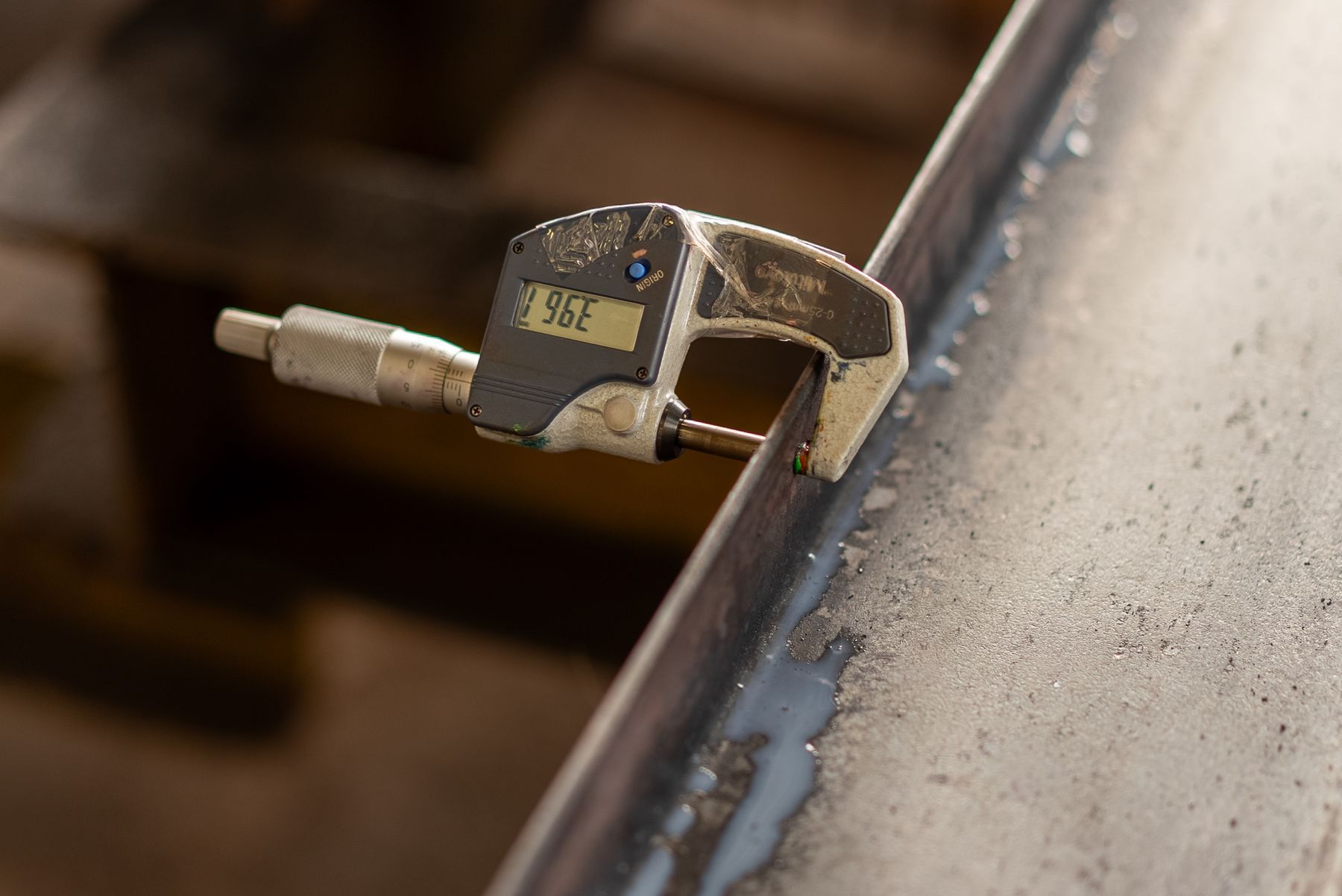 Digital caliper measuring a steel part